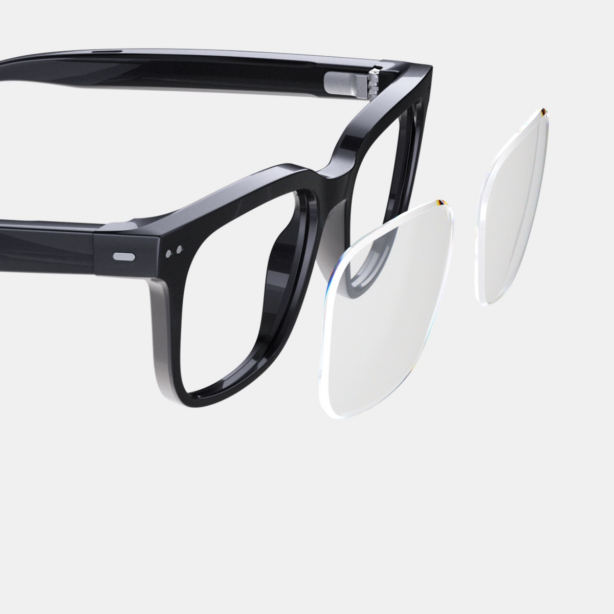 Black eyeglasses with a clear lens cover on a light gray background